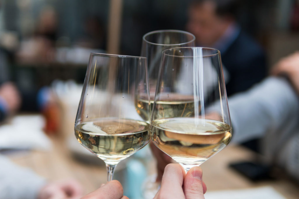 Three glasses of wine clinking together for a 'cheers'